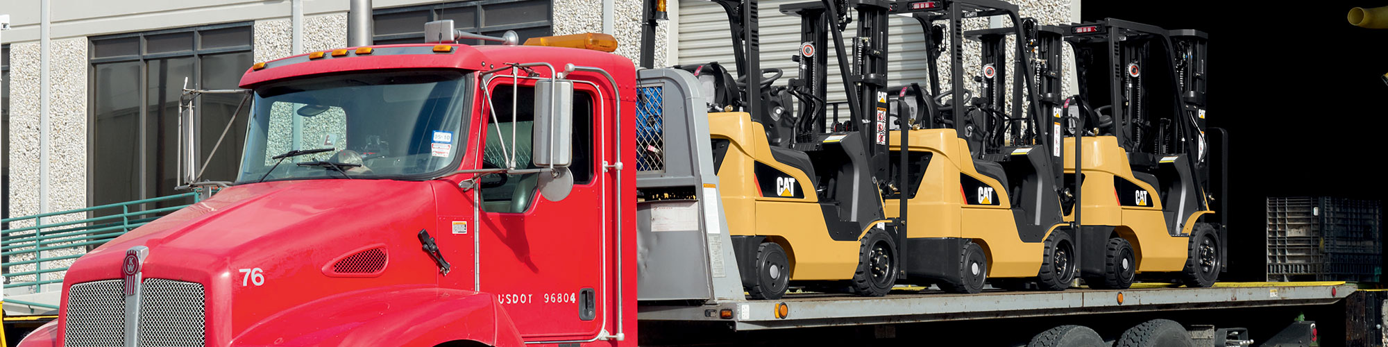 Cat forklifts on delivery truck