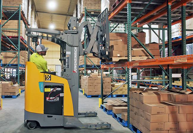 Jungheinrich narrow aisle forklift getting stuff off shelf